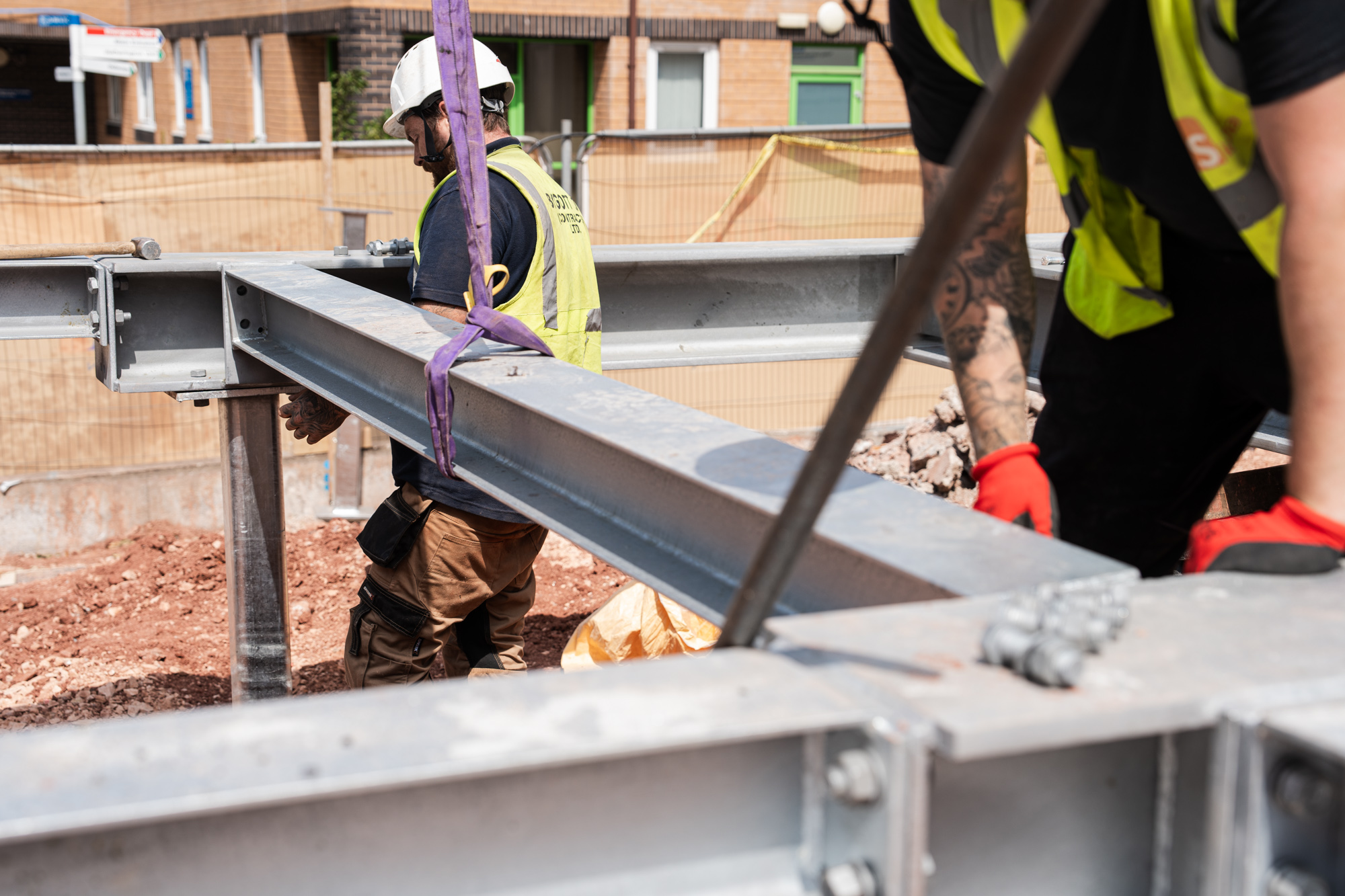 a close up view of construction workers installing a steel beam